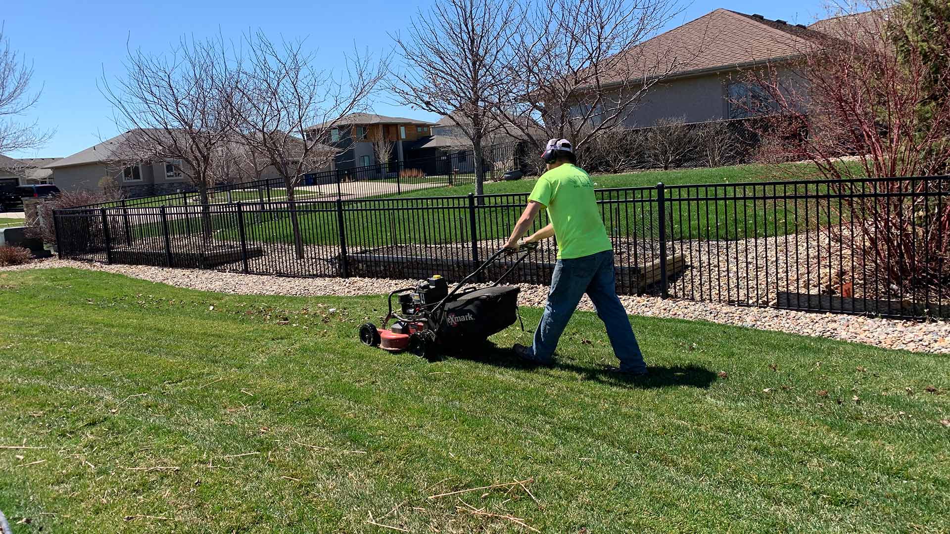 Lawn care worker mowing a lawn near Harrisburg, SD.
