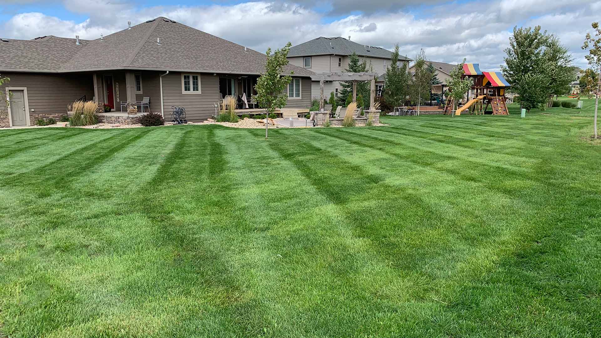 Lush, green lawn near a home with landscape maintenance in Tea, SD.